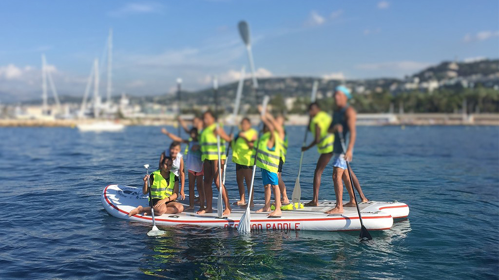 Enfants sur paddle g&eacute;ant collecte de d&eacute;chets Cannes