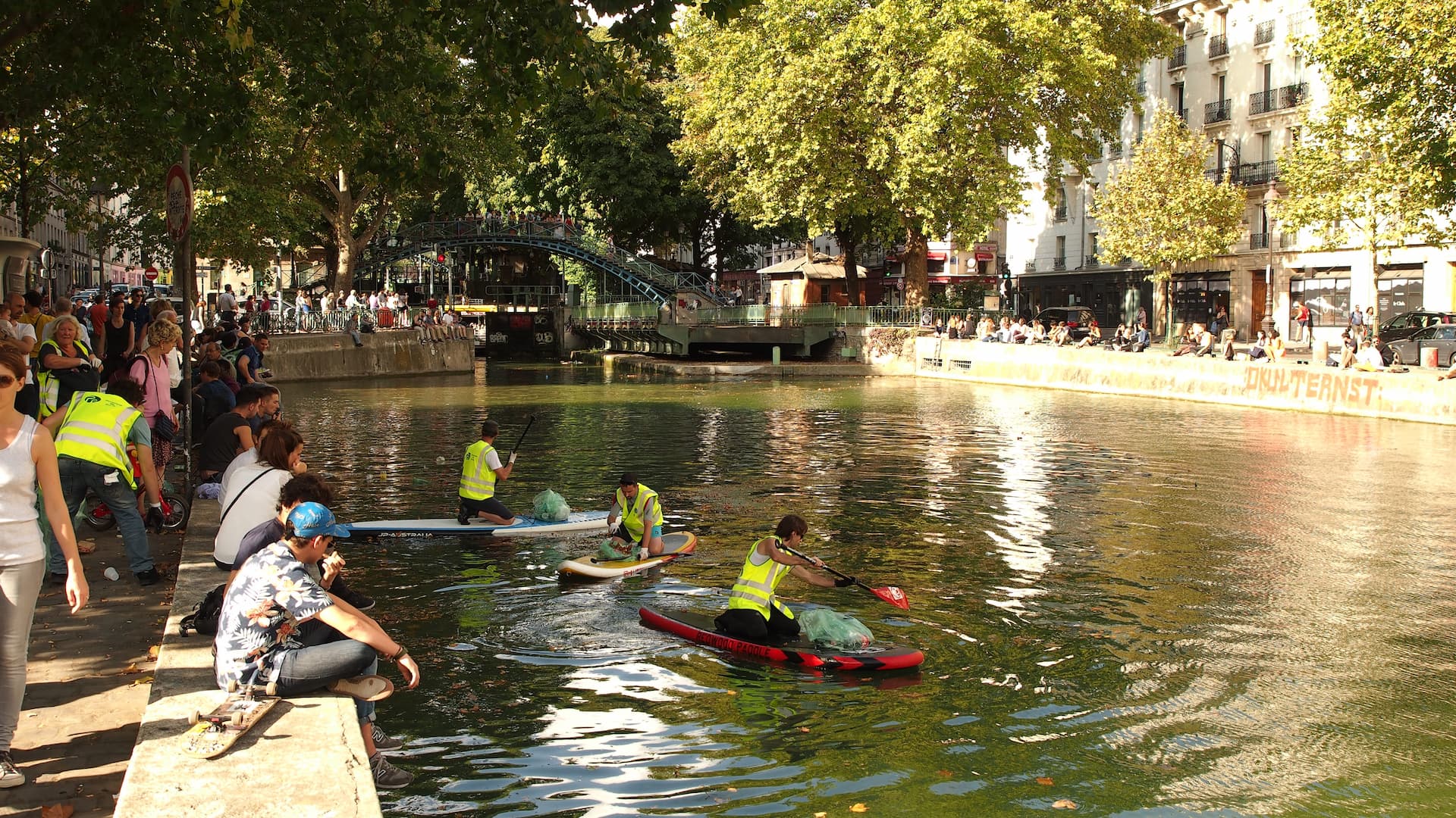 Ramassage de d&eacute;chets en paddle sur le canal Saint Martin par des b&eacute;n&eacute;voles de l'association Watertrek